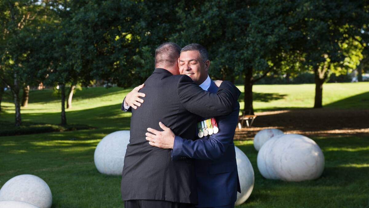 Veteran Ben Farinazzo embraces retired lieutenant colonel Simon Moore-Wilton. The pair served together in East Timor. Picture by Sitthixay Ditthavong
