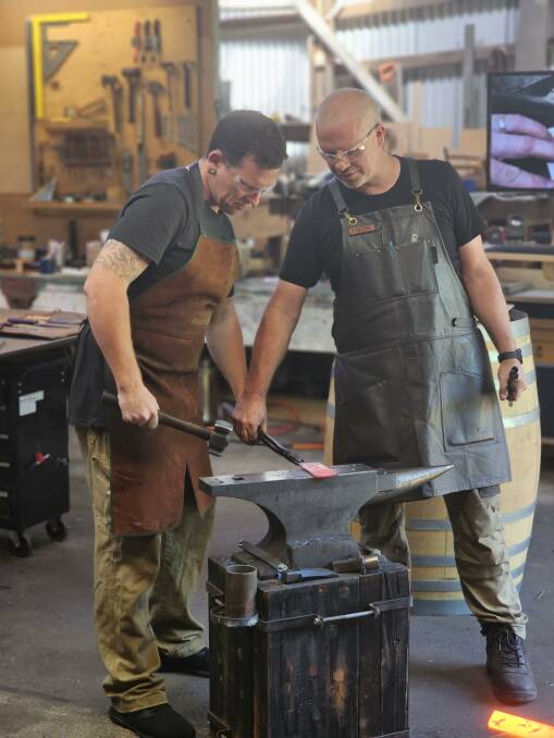 Blacksmith Chris Stratford (right) helps one of the participants. Picture supplied