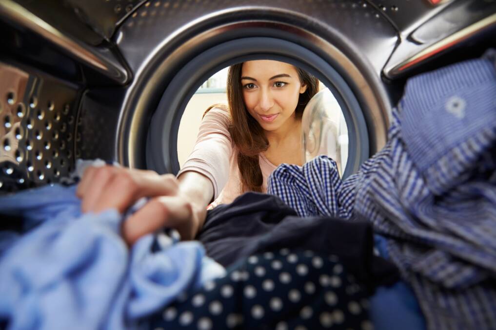 A woman pulling clothes from a front loader washing machine. Shutterstock picture