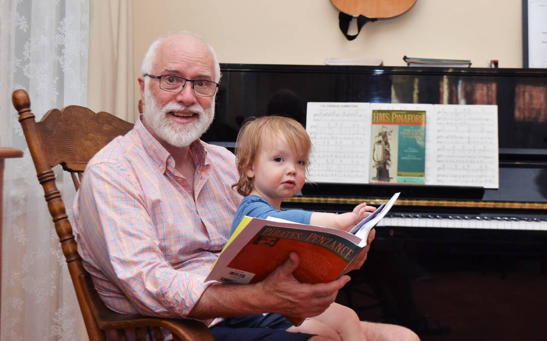 Douglas McNicol with his grandson Fraser reading the music to 'Pirates of Penzance'. Picture by Anthony Caggiano