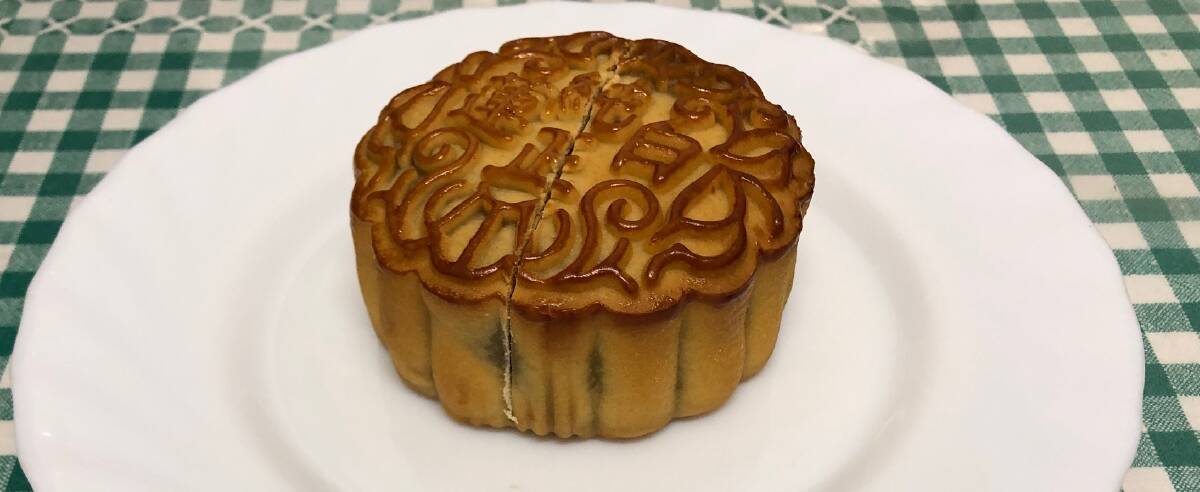 A white lotus seed mooncake cut in half on a plate. Picture by Anthony Caggiano