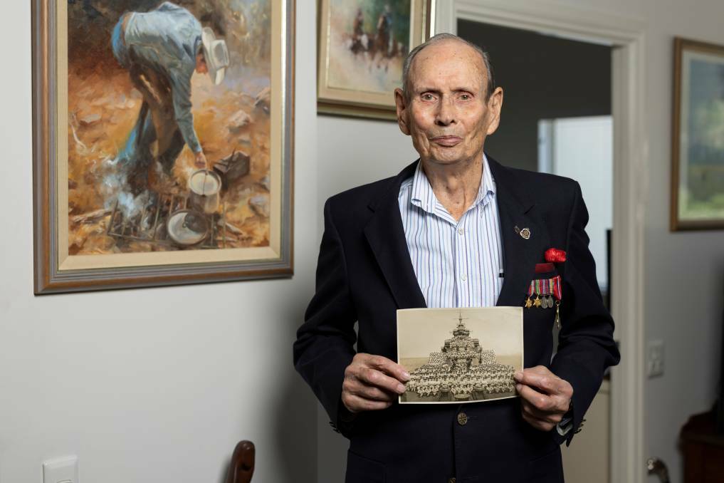 World War II veteran Colin (Russ) Gibbins holding a picture of HMAS Shropshire. Picture supplied