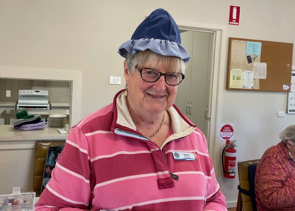Narooma CWA president Marie Warden said wearing the clothes made from the uniforms of ambulance and police officers helps the children form a bond with those frontline officers. Pictured with one of the hats they made for the children. Picture by Marion Williams.