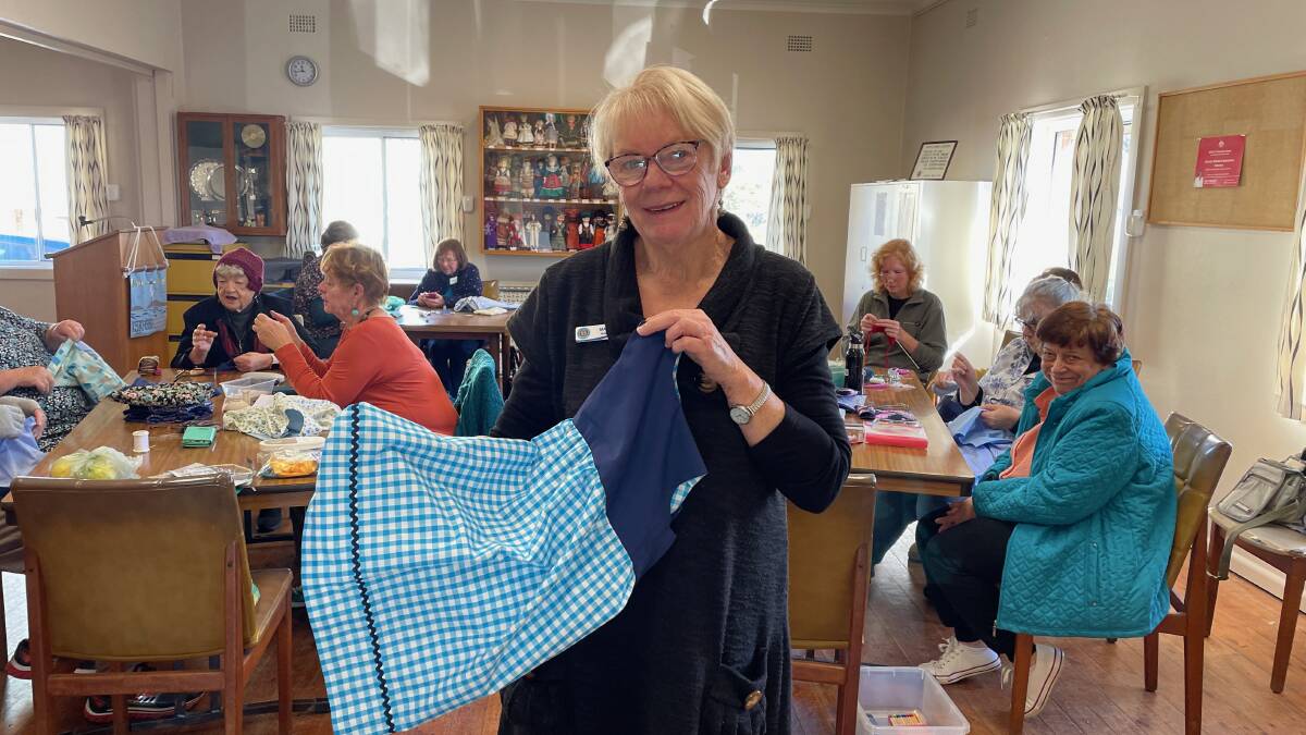 Narooma CWA branch handicraft officer Marion Cullen with one of the dresses they have made from the uniforms of ambulance and police officers. A group of CWA women gathered at the Narooma CWA rooms on Friday, June 30, to put the finishing touches on the items. Picture by Marion Williams.