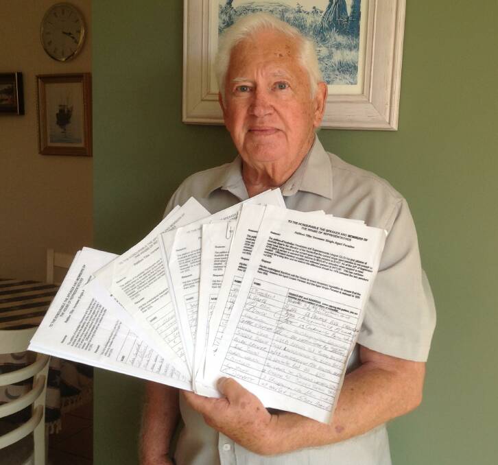CRIPPLING CUT: Frank Gower with the petitions tabled in parliament two years ago.