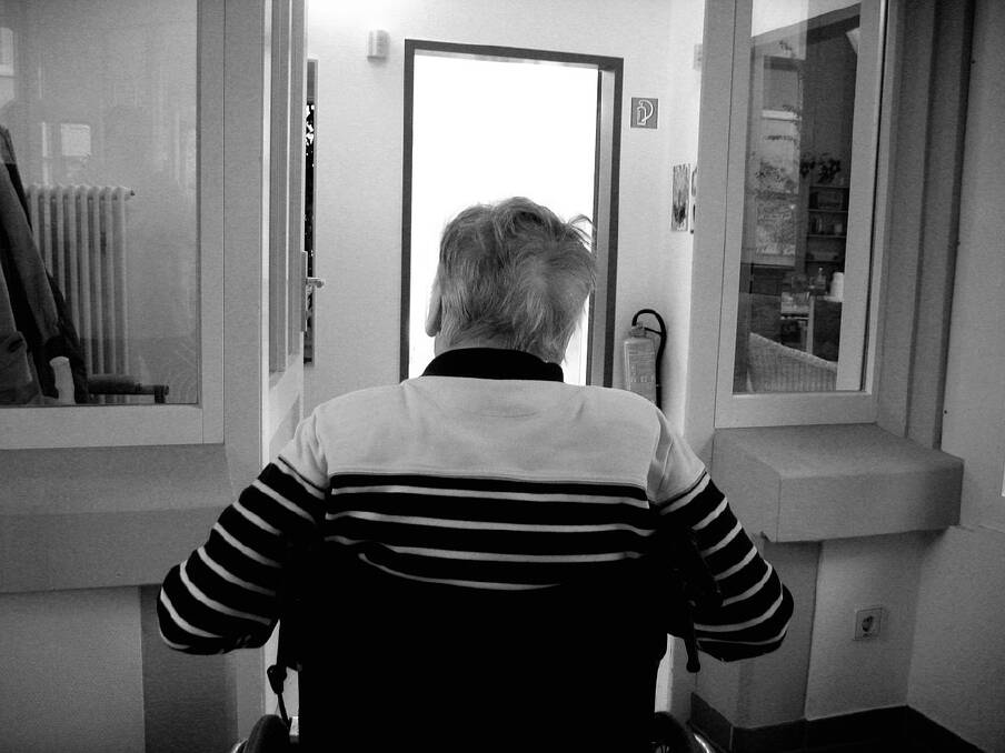 A senior in a wheelchair going through a doorway. Pixabay picture.